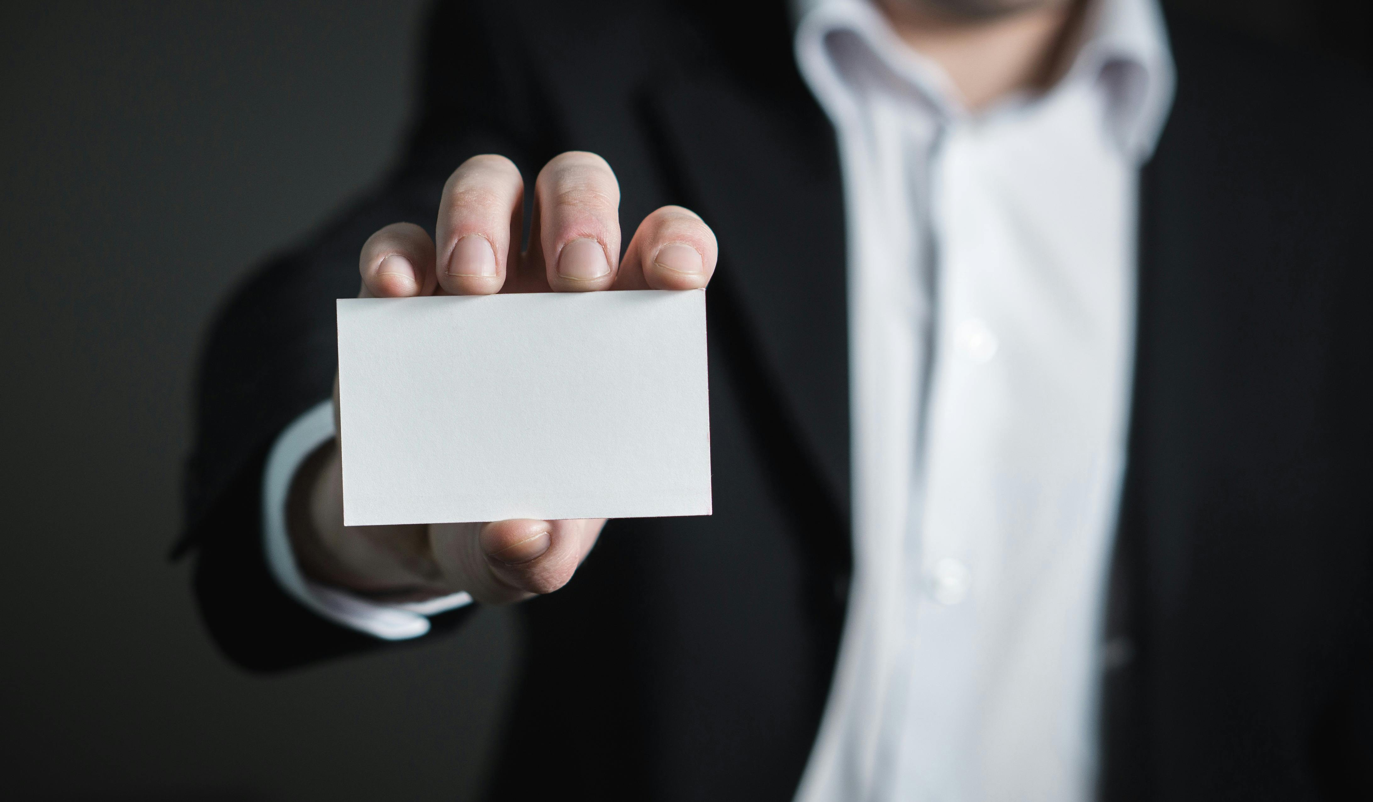 A man holding a blank business card. The image is to help see that we have a blank card on which we can build our brand identity as we want.